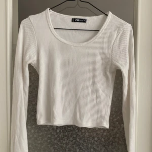 Vit ribbad croppad tröja  - Säljer en superfin vit ribbad tröja från F21. Den är croppad och har långa ärmar, perfekt för både vardag och fest. Tröjan är i nyskick och väldigt bekväm att ha på sig. Passar perfekt till höst och vår outfits! 💫