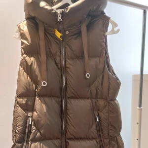 Parajumper väst - Säljer denna olivgröna parajumper väst då den inte används nyskick färgen är utsåld och köptes ifrån Next, västen är väldigt varm och luftig och har 2 dragkedjor där bak som går att öppna storlek xs passar s och m, nypris 11370:- säljer för 8999:-🫶🏼