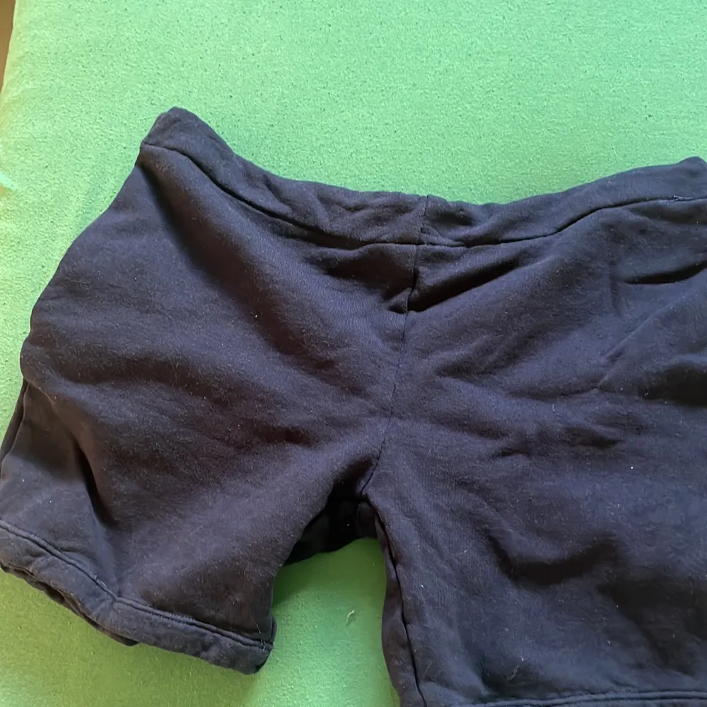 Säljer ett par svarta bomullsshorts med snörning i midjan. De är superbekväma och perfekta för både träning och chill. Shortsen är i bra skick och har en normal passform. Perfekta för sommaren!. Shorts.