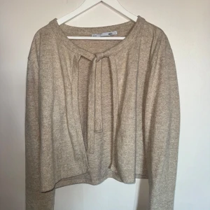 Supermjuk kofta från lager157 (oanvänd) - Säljer en stilren beige kofta från lager157 med knytband framtill. Supermjuk och skön att använda. Enkelt att matcha med olika outfits. 