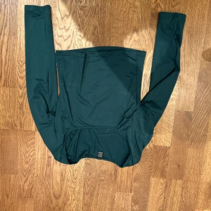 Grön långärmad topp från SHEIN - Snygg grön långärmad topp från SHEIN. Perfekt för en stilren look med sin enkla design och mjuka material. Passar bra till både jeans och kjol.
