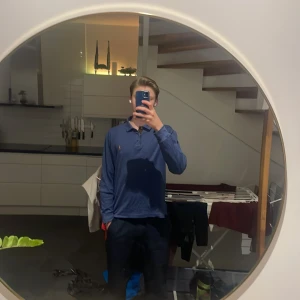 Blå pikétröja från Ralph Lauren - Säljer en stilren blå pikétröja från Ralph Lauren. Tröjan har en klassisk krage med tre knappar och det ikoniska broderade logotypen på bröstet. Perfekt för en avslappnad men ändå elegant look. Den är enkel att köra lager på lager med vilket kan skapa feta outfits🔥 säljer den för de låga priset 450 när nypriset går för runt 1000 kr. Skriv för andra bilder eller mer! 