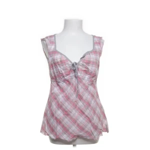 Rosa blus  - Söt ärmlös blus med rutigt mönster i rosa och vit. Den har en knytning framtill och en lätt utsvängd passform. Perfekt för varma sommardagar. Be om fler bilder/bilder med passform! 