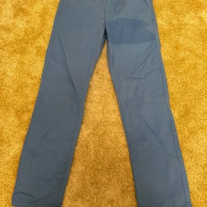 Blå byxor från Lager 157 - Blå byxor med justerbar midja och stjärnmönstrat foder.  Märke: Lager157 Kön: pojke Storlek: 140 Skick nyskick Ord. Pris: 150 SEK