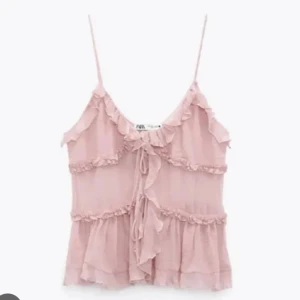 Rosa volanglinnetopp från Zara - Säljer denna slutsålda topp ifrån Zara. Andvänd ett fåtal gånger. Tröjan har knytningar framtill. Perfekt nu till sommaren. Skriv gärna för flera bilder. Pris går inte att diskutera💗