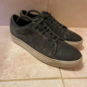 Lanvin skor - Snygga grå sneakers i mocka från landvind.  Skorna har en vit sula som ger en stilren kontrast. Perfekta för en avslappnad stil. Skorna har en liten defekt(SE BILD 3) . Är även öppen för byten.