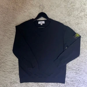 Stone Island tröja - Säljer en stilren svart tröja från Stone Island. Aldrig andvänd pga att de ej är min stil. Perfekt för en avslappnad look med den ikoniska loggan på ärmen. Priset kan diskuteras vid en snabb affär.