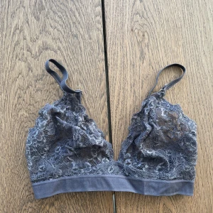 Grå spetsbralette från Lindex - Säljer en elegant grå spetsbralette från Lindex. Den har justerbara axelband och en mjuk resår under bysten för extra komfort. 