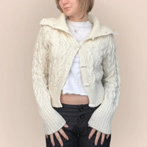 Vit stickad kofta från EDC - Säljer en mysig vit stickad kofta från EDC med knappar framtill och ett snyggt flätmönster. Koftan har långa ärmar och en hög krage som kan vikas ner. Jag på bilden har strl 36 på överdelar och är 170cm. Klicka på köp nu <3