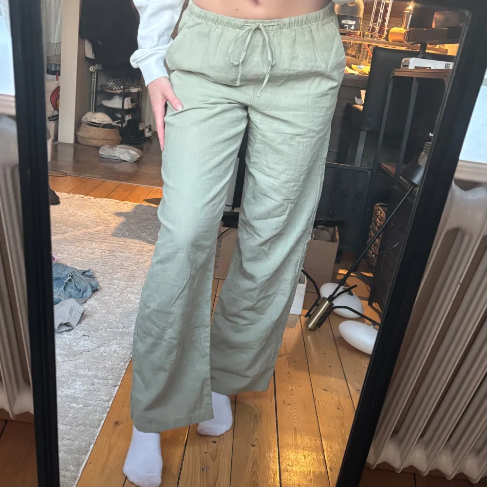 Snygga gröna linnebyxor från Gina Tricot i storlek XS. Byxorna har en loose passform med hög midja och dragsko i midjan för extra komfort. Perfekta för en avslappnad stil. Endast använda 1 gång.. Farkut & Housut.