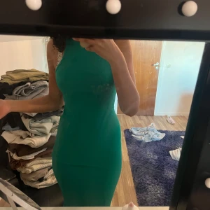 Grön ärmlös klänning - Snygg grön ärmlös klänning med en tight passform. Perfekt för att sticka ut med sin stilrena design. Klänningen har en enkel och elegant look.