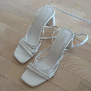 Vita klackskor  - Eleganta vita klackskor från Bershka med smala remmar och klack. Brukar variera mellan storlek 38-39 på skor, dessa är 39. 