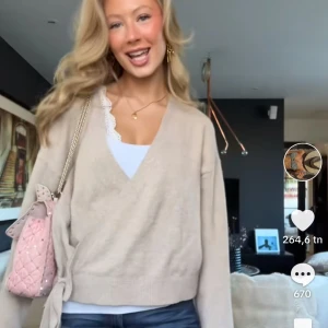 Beige omlottkofta - Säljer en mysig beige omlottkofta med knytning i sidan. Koftan har långa ärmar och en v-ringad design, perfekt för en stilren och bekväm look. PRIS KAN DISKUTERAS!!