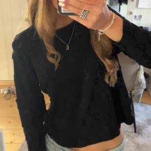 Svart långärmad topp med textur - Jättefin svart långärmad topp med unik textur. Perfekt för att ge en extra touch till din outfit. Vet tyvärr inte märket💓