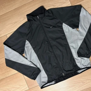 Svart och grå vintage nike jacka - Säljer en nike vintage jacka, finns lite tecken på slitage vid reflexerna, men inte något man märker direkt. Är öppen på prisförslag. 