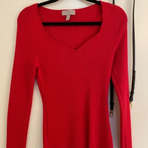 Röd ribbad tröja från H&M - Säljer en snygg röd ribbad tröja från H&M. Tröjan har en v-ringad hals och långa ärmar, perfekt för en stilren look. Passar bra till både jeans och kjol. Perfekt för höst och vinter!