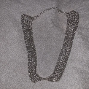Silverfärgat halsband med kedjedesign. Använd några gånger  - Snyggt silverfärgat halsband med en unik kedjedesign. Halsbandet har en justerbar kedja och ett karbinlås för enkel användning. Perfekt för att ge en edgy touch till din outfit.