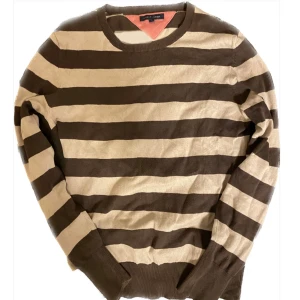 Brun och beige randig tröja Tommy hilfiger  - En brun och beige randig tröja från Tommy Hilfiger. Tröjan är i XS/S och säljer då den är för liten för mig. Hör av dig vid intresse eller fundering, pris kan diskuteras!