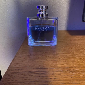 Nautica Voyage parfym - Fräsch och marin doft från Nautica Voyage i en stilren, fyrkantig flaska med blått innehåll. Flaskan har en silverfärgad kork som ger en elegant touch. Perfekt för den som älskar havets friska bris.