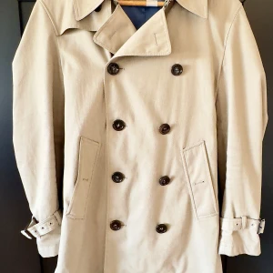 Trenchcoat - Used carefully. Cotton and polyester mix.