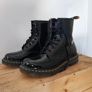 Dr Martens boots - Doc Martens lackade boots i mycket gott skick! Storlek 38. Enadst använda ett par gånger; säljer pga att de tyvärr är för stora för mig. Köpt pris: 1890kr 