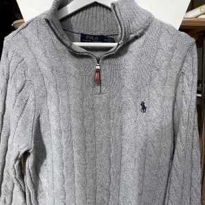 Grå stickad tröja  - Grå kabelstickad tröja från Ralph lauren  Halvzip Skick 9/10 Väldigt populär modell och perfekt för vintern  Org. Pris 2695kr Pris kan diskuteras vid snabb affär🤝🏻