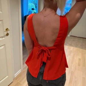 Röd topp med knyte i ryggen - Röd topp med knyte i ryggen. Använd någon enstaka gång. Storlek 34.