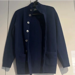 Alan paine buttoned up cardigan - Säljer nu denna mycket eftertraktade cardiganen från Alan paine, perfekt för de lallare säsongerna. Den är stickad och är i mycket bra skick. Storleken är S och den passar om man är mellan ca 170-180