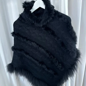 Svart gosig poncho - Svart poncho med äkta päls från Jätte söt svart lurvig poncho från Mirelle design. Det är en Onesize och den har även en luva.  Nypris 1200 säljes 250!