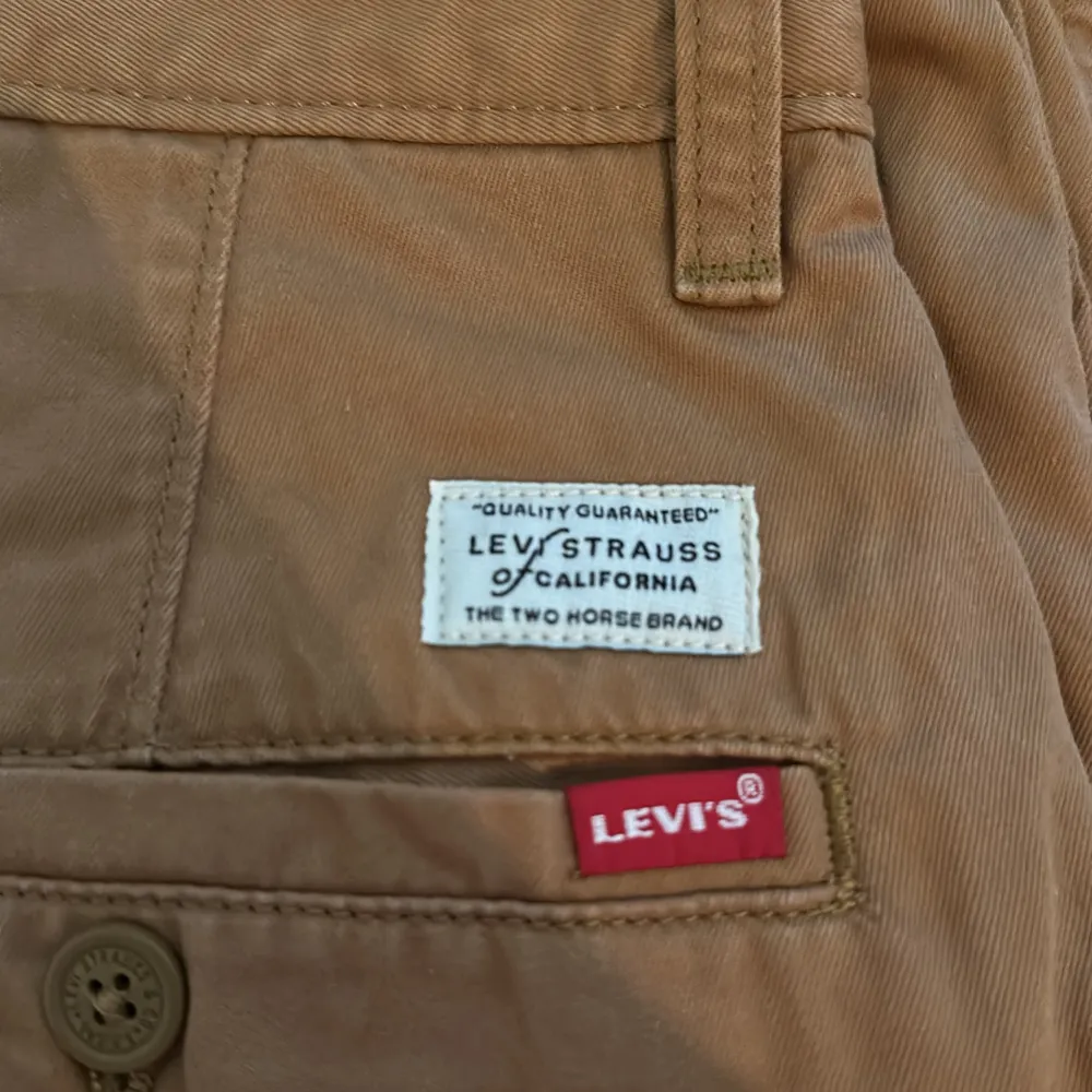 Säljer ett par snygga bruna chinos från Levi's i modellen XX Chino. De har en loose fit och är perfekta för en avslappnad stil. Byxorna är Perfekta för höst och vår, de är lite korta i benen!. Jeans & Byxor.