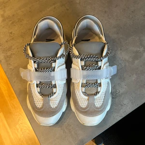 Moschino skor - Superfina och unika Moschino sneakers. Bra skick på dojorna 8/10 skulle jag säga.  Det är storlek 42. Använda några gånger. Ovansidan på skorna är av reflex material, vilket gör att framsidan på skon lyser om den reflekteras av något ljus i mörker. 