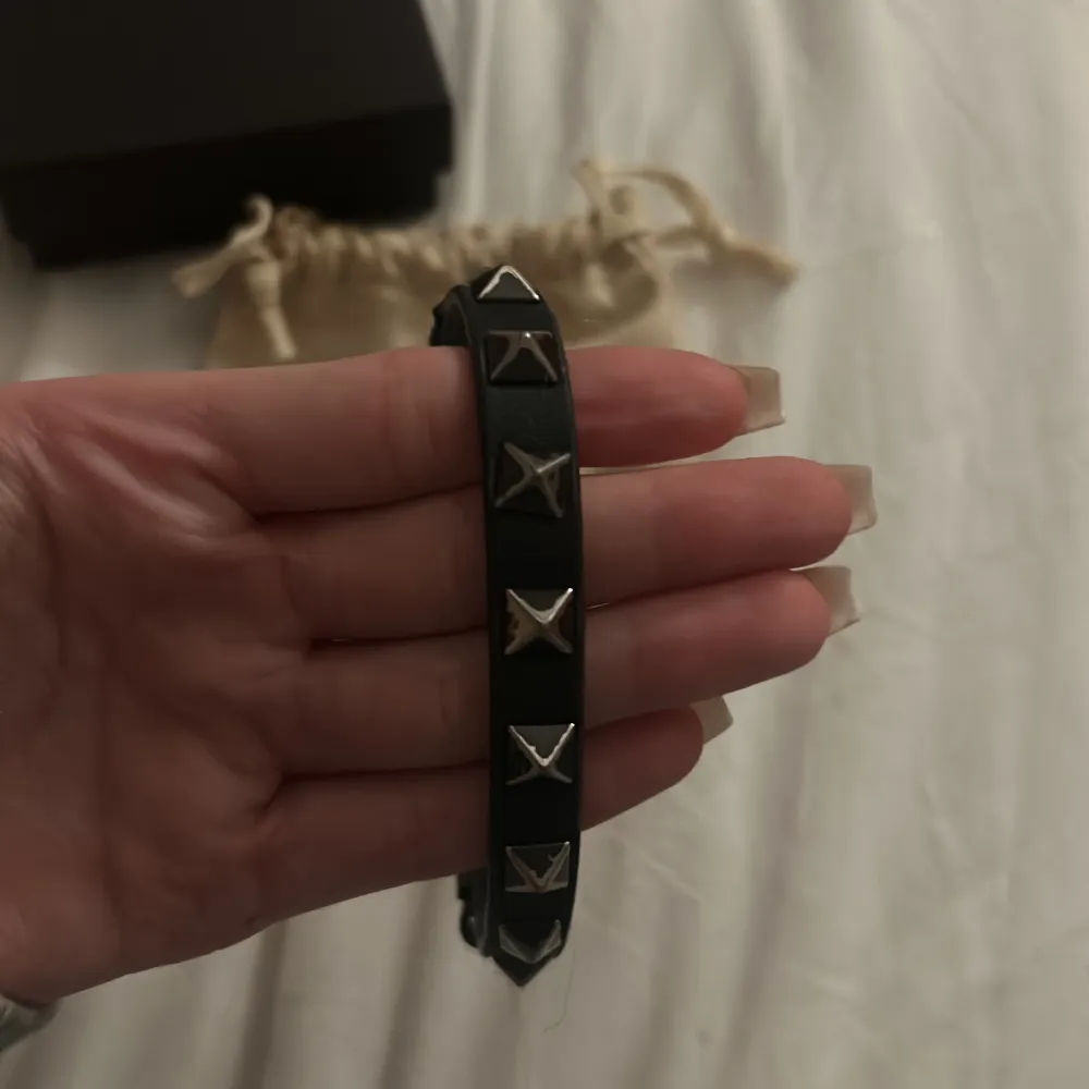 Säljer ett snyggt svart armband från Valentino. Armbandet är välandvänt och har som man ser på bilderna släppt lite, men det funkar alldeles utmärkt att använda det. Orginalask, äkthetsbevis och påse finns med.  Köpt för 2800 kronor.  Pris kan diskuteras !!💕💕💕. Accessoarer.