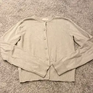 Säljer en stilren beige/gröna kofta från H&M i storlek XS. Den är i mycket bra skick och har långa ärmar med knappar framtill. Perfekt för både höst och vår, och passar till de flesta outfits. Supermjuk och bekväm att ha på sig!