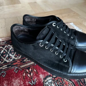Lanvin skor - Säljer ett par stilrena svarta sneakers från Lanvin i mycket bra skick. Det är storlek 42. Riktigt fräscha skor som är perfekt nu för vintern. Pris är endast 1899kr. Köpta för 3700kr. Vid frågor så är det bara att skriva🔥