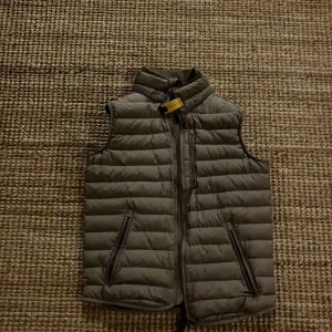 Grå dunväst med dragkedja (parajumpers) - 100 procent äkta köpte den för 4200 för ett år sen har bara använt den ett par gånger den är som ny. Storleken är xs men passar mig fortfarande och jag har S.