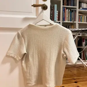 Säljer en superfin vit/beige ribbad stickad topp från Zara i storlek S. Den har korta ärmar och är perfekt för både vardag och fest. Toppen är i mycket bra skick och passar perfekt till jeans eller kjol. Ett måste i garderoben! 🤍