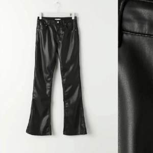 Snygga svarta skinnbyxor i bootcut-stil. Perfekta för en kväll ute eller en cool vardagslook. Byxorna har en glansig finish och en klassisk femficksdesign. De är både trendiga och bekväma, och passar perfekt till både klackar och sneakers.low waist