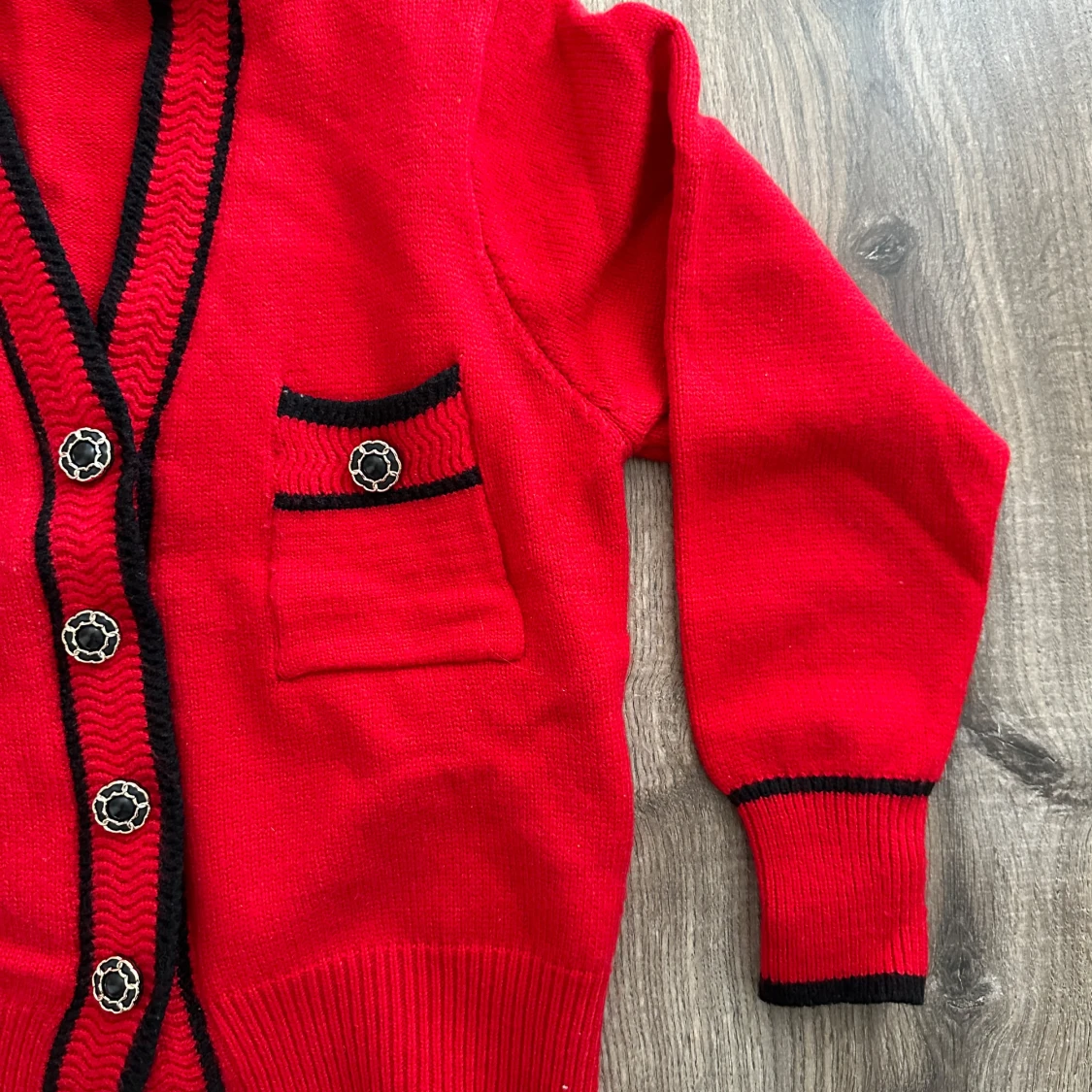 Röd kofta med svarta detaljer