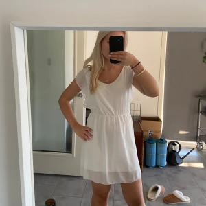 Vit sommarklänning - Säljer en söt vit sommarklänning i lätt och luftigt material. Den har en enkel design med korta ärmar och en elastisk midja som ger en fin passform. Perfekt för varma sommardagar eller en avslappnad dag på stan. 🏖️