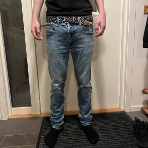 Blå jeans från Replay - Säljer ett par snygga blå jeans från Replay i modellen Anbass. De har en slim passform och är i mycket bra skick förutom att det är ett hål som enkelt går att laga i vänstra fickan som ni ser på bild 5. Storleken är 32/34 men skulle säga att dem sitter mer som 32/32 eftersom modellen är 180 och väger 63. 