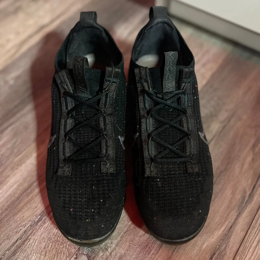 Säljer ett par svarta Nike Vapormax sneakers i bra skick. De har en stilren design med snörning och är perfekta för både träning och vardagsbruk. Skorna är gjorda i syntetmaterial och har en bekväm passform. Perfekta för dig som vill ha både stil och komfort! En sula har lite mindre luft än den andra men det går att fylla på. Priset är inte hugget i stel men kan diskuteras!!!( Ena skorn har hål i bubbelsulan). Kengät.