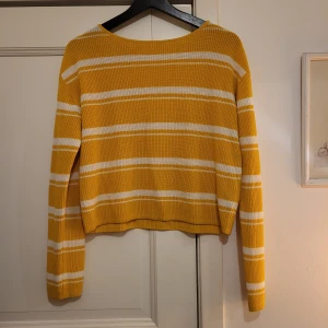 Gul och vit randig tröja från H&M - Säljer en superfin gul och vit randig tröja från H&M. Den är stickad och har en normal passform med långa ärmar. 