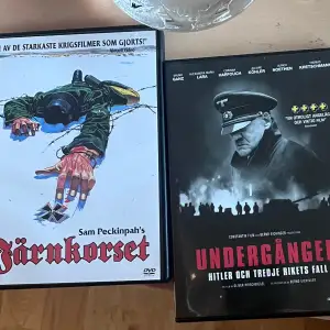 Två DVD-filmer: 'Järnkorset' av Sam Peckinpah och 'Undergången: Hitler och tredje rikets fall'. Omslagen visar dramatiska krigsscener och historiska teman.