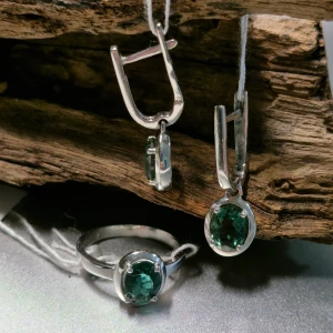 Snyggt smyckeset i 925 silver med gröna stenar - Ett elegant smyckeset med örhängen och ring i silver. Båda har vackra gröna stenar som ger en lyxig känsla. Perfekt för att piffa upp vilken outfit som helst. Örhängena har en enkel och stilren design med en säker låsning.   Örhängen: Vikt: 4,10 gram Sten: grön kvarts 2.18 ct Ring: Vikt: 2,50 gram Sten: grön kvarts 1.09 ct Storlek: 17
