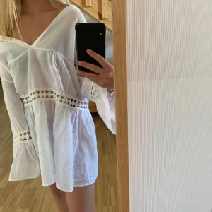 Vit klänning från Trendyol - Säljer en superfin vit klänning från Trendyol i storlek 34. Den har v-ringning och vackra spetsdetaljer som ger en romantisk touch. Perfekt för sommarens alla fester! Klänningen har trekvartsärmar och en luftig passform.