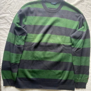 Randig tröja från Redgreen - Säljer en snygg randig tröja från Redgreen i storlek L. Den har breda gröna och svarta ränder och är perfekt för både höst och vinter. Tröjan är långärmad och har en klassisk rund halsringning. Perfekt för en avslappnad stil!