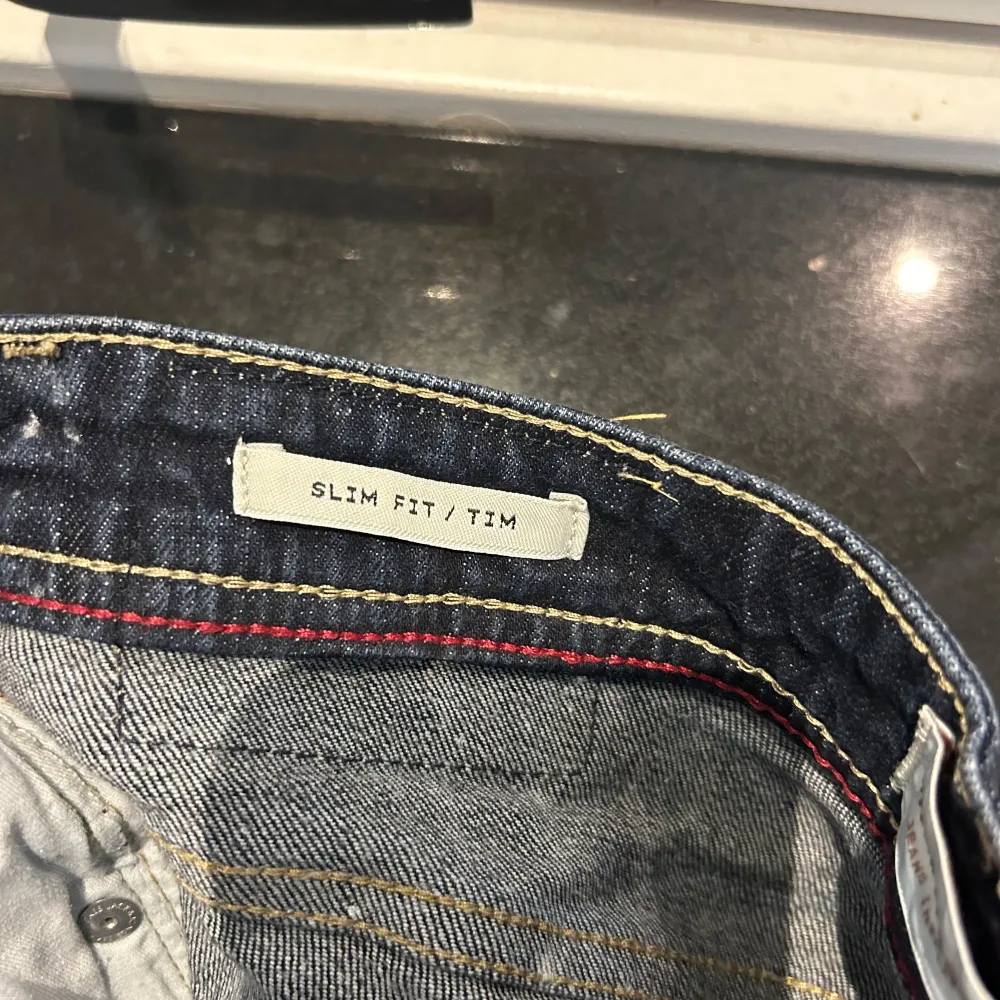 Säljer ett par snygga mörkblå jeans i slim fit-modell. De har en klassisk femficksdesign och är perfekta för både vardag och fest. Jeansen är i bra skick och har en bekväm passform. Perfekta för höst och vår!. Jeans & Byxor.