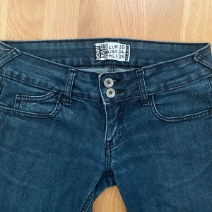 Lågmidjade jeans - Grå/blå lågmidjade jeans med snygga knappar! 