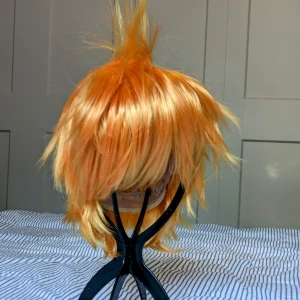 Jättefin orange peruk - Jättebra skick, inget trassel. Köpt nytt och har använts endast en gång. Funkar bra till många olika cosplays. Toffsen på toppen kan tas ut.