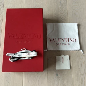 Valentino Garavani skokartong med tillbehör - Säljer en elegant röd skokartong från Valentino Garavani. Inkluderar en vit dustbag. Perfekt för att förvara eller transportera dina lyxiga skor. Allt i mycket bra skick. SNÖRENA ÄR SÅLDA !